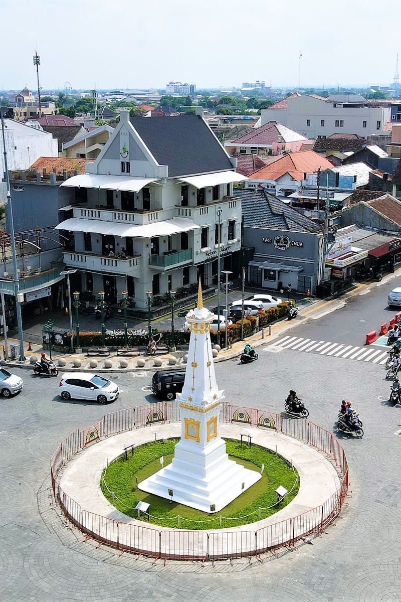 A vibrant aerial view of the Tugu monument in Yogyakarta, Indonesia, with bustling city life.